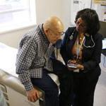 Frias Radhame, 76, a tuberculosis patient at Lynn Community Health Center, consulted Dr. Hanna H. Haptu.