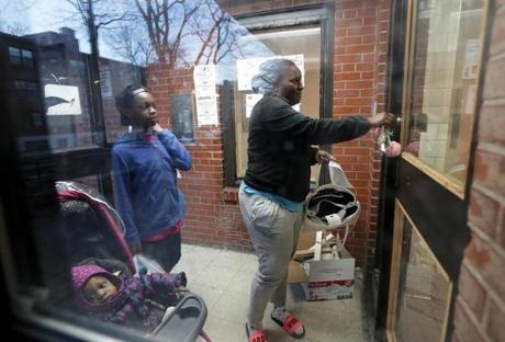 Boston, MA: 02-22-2017: Kyiesha Menzie arrives home at the Mildred C. Hailey Apartments, formerly known as Bromley-Heath, in the Jamaica Plain n neighborhood of Boston, Mass. Feb. 22, 2017. With her Is her daughter Summer Murrain (in carriage) and her son Jordan Cage (another son Joseph Murrain was there but can't be seenn). Photo/John Blanding, Boston Globe staff story/Evan Allen ( 23hailey )
