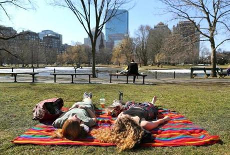 Boston broke the official high temperature for the day as Lesley University students Alexis Peck (left) and Caroline Acquaviva soaked up the sun on a blanket at the Boston Public Garden.
