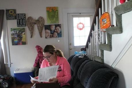 Lindsey Keane, a Woburn mother whose toddler son Noah died of traumatic head injuries while he was being cared for by a baby sitter, went through paperwork she keeps on file.    

