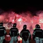 Anti-riot police officers stood guard as Red Star Belgrade's supporters burned torches after a match against rival Partizan.