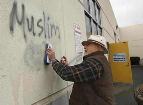 In February, Tom Garing cleans up racist graffiti painted on the side of a mosque in Roseville, Calif.
