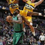 Boston Celtics forward Amir Johnson, front, goes up for a basket as Denver Nuggets guard Gary Harris, back left, and center Mason Plumlee defend during the second half of an NBA basketball game Friday, March 10, 2017, in Denver. The Nuggets won 119-99. (AP Photo/David Zalubowski)