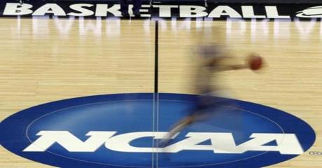 FILE - In this March 14, 2012, file photo made with a long exposure, a player runs across the NCAA logo at midcourt during practice in Pittsburgh before an NCAA tournament college basketball game. Duke and North Carolina State were among the top 16 projected seeds the NCAA revealed Monday, Feb. 6, 2017 for the women's basketball tournament in March, making them potential hosts in a state that's lost several sports events because of a divisive law. (AP Photo/Keith Srakocic)
