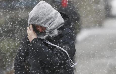 SNOW SLIDER 1 Boston, MA -- 3/14/2017 - A woman covered her face to try and block the blowing snow as she crossed the street in Boston. (Jessica Rinaldi/Globe Staff) Topic: 15storm Reporter: 
