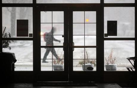 SNOW SLIDER 1 Brookline, MA - 03/14/17 - A pedestrian passes in front of the Arcade Building during heavy snowfall in Coolidge Corner. (Lane Turner/Globe Staff) Reporter: () Topic: (15storm)
