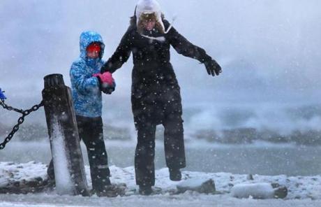 SNOW SLIDER2 Scituate-03/14/2017 Malin Agostino from Scituate holds on to her daughter Lily as they came to look at the waves crashing on to the breakwater in Scitutae Harbor, as strong winds blew the snow sideways.John Tlumacki/Globe staff(metro)
