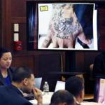A screen shows a photo of the tattooed hand of defendant Aaron Hernandez, lower left, during testimony in his double murder trial in Suffolk Superior Court, Wednesday, March 15, 2017, in Boston. Hernandez is on trial for the July 2012 killings of Daniel de Abreu and Safiro Furtado who he encountered in a Boston nightclub. The former New England Patriots NFL football player is already serving a life sentence in the 2013 killing of semi-professional football player Odin Lloyd. (AP Photo/Elise Amendola, Pool)