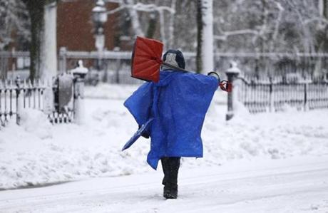 A man carried shovels down Commonwealth Avenue in Boston on Tuesday. 
