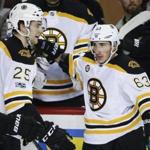 Boston Bruins' Brad Marchand, right, celebrates his goal with teammate Brandon Carlo during second period NHL hockey action against the Calgary Flames in Calgary on Wednesday, March 15, 2017. (Jeff McIntosh/The Canadian Press via AP)