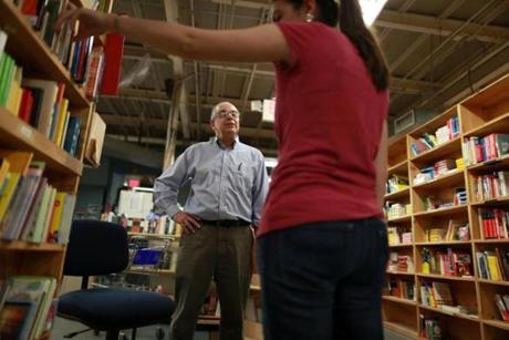 Tom Lyons, owner of New England Mobile Book Fair in Newton, talks to a customer in 2013. 
