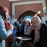 Sarah Kilgallon, of Watertown, accepted a date from worshippers Yusra Mukhtar and Nafisa Bilal outside the Islamic Society of Boston Cultural Center in Boston in February.