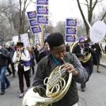 Boston, MA - 3/28/2017 - Jordan Volel,12, a student from the Conservatory Lab Charter School plays his French horn as he marches to the State House during what organizers called an 