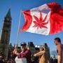 A woman waved a flag with a marijuana leaf on it next to a group gathered to celebrate National Marijuana Day last year on Parliament Hill in Ottawa, Canada.
