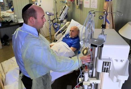 At Hebrew Senior Life, Dr. Ernest Mandel prepared to administer dialysis to patient John Glynn. 
