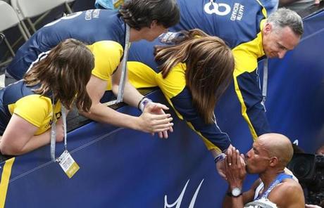 slider_Boston, Massachusetts -- 4/17/2017 - American runner Meb Keflezighi kisses the hand of Denise Richard as other members of the Richard family (L-R:) Jane, Henry and Bill reach out to applaud him after he crossed the finish line of the 121st Boston Marathon. This will be his last competitive Boston Marathon. (Jessica Rinaldi/Globe Staff) Topic: Marathonpics Reporter: 
