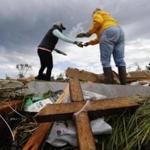 Women retrieved items Sunday from the remains of a trailer home in Canton, Texas, that was destroyed by a tornado.