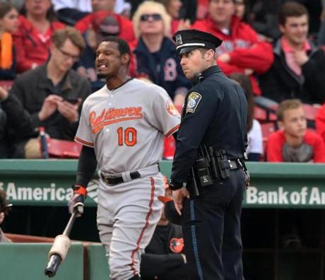 Boston, MA May 1, 2017: A Boston police officer is outside the visitor's dugout as the Orioles Adam Jones (10) heads for the on deck circle just before the start of the game. The Boston Red Sox hosted the Baltimore Orioles in a regular season MLB base ball game at Fenway Park. (Globe Staff Photo/Jim Davis)
