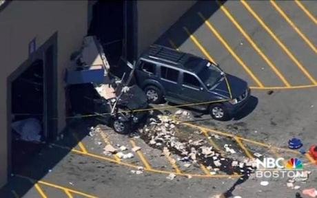 This still image from video provided by NBC Boston shows wreckage after a vehicle suddenly accelerated at an auto auction and struck several people before it crashed through a wall of the building, Wednesday, May 3, 2017, in Billerica, Mass. (NBC Boston via AP)
