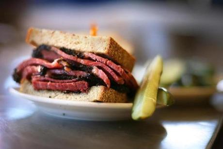 A pastrami sandwich served with a side of pickles at Katz's Delicatessen in New York. 
