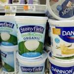 Stonyfield and Dannon yogurts are stacked on a supermarket shelf, Tuesday, April 4, 2017, in New York. Danone will sell its Stonyfield Farms business to gain approval from the U.S. for a $12.5 billion buyout of Denver's WhiteWave Foods, doubling the size of the French company's business in North America. (AP Photo/Mark Lennihan)