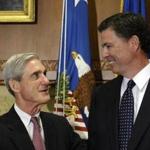 Incoming FBI Director James Comey talks with outgoing FBI Director Robert Mueller before Comey was officially sworn in at the Justice Department in Washington, Wednesday, Sept. 4, 2013. (Susan Walsh/AP Photo)