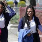 Mya Cook, left, and her sister Deanna Cook, right, attend Mystic Valley Regional Charter School and have served multiple detentions for wearing hair extensions.