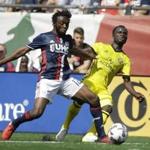 New England Revolution midfielder Xavier Kouassi, left, and Columbus Crew midfielder Mohammed Abu, right, vie for control of the ball during the first half of an MLS soccer game, Sunday, May 21, 2017, in Foxborough, Mass. (AP Photo/Steven Senne)