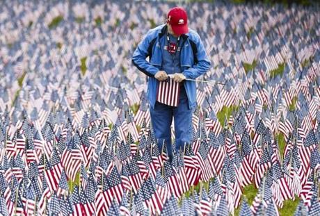 Boston, MA - 5/28/2017 - George Rohlfing, a volunteer for the Massachusetts Military Hero Fund, holds flags in the annual Memorial Day Flag Garden on Boston Common in Boston, MA, May 28, 2017. Over 37,000 flags are planted in the ground on the hill leading to the Soldiers and Sailors Monument to represent the military personnel from Massachusetts killed in combat since the Revolutionary War.(Keith Bedford/Globe Staff)
