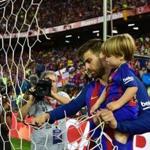 Barcelona defender Gerard Pique holds his son Sasha as he cuts a part of the net at the end of the Spanish Copa del Rey final match last weekend in Madrid.
