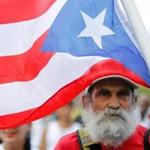 A man carries a Puerto Rican flag during a protest against the referendum for Puerto Rico political status in San Juan, on June 11, 2017. To become a true US state, to choose independence or to maintain the status quo: Puerto Ricans went to the polls to consider their political future in a non-binding referendum many have vowed to boycott. / AFP PHOTO / Ricardo ARDUENGORICARDO ARDUENGO/AFP/Getty Images