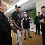 Former NBA star Dennis Rodman (center) was greeted by North Korea's Sports Ministry Vice Minister Son Kwang Ho (right) on Tuesday upon arriving in Pyongyang.