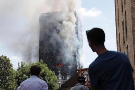 LONDON FIRE SLIDER Pedestrians look up towards Grenfell Tower, a residential block of flats in west London on June 14, 2017, as firefighters continue to control a fire that engulfed the building in the early hours of the morning. Shaken survivors of a blaze that ravaged a west London tower block told Wednesday of seeing people trapped or jump to their doom as flames raced towards the building's upper floors and smoke filled the corridors. / AFP PHOTO / Adrian DENNISADRIAN DENNIS/AFP/Getty Images
