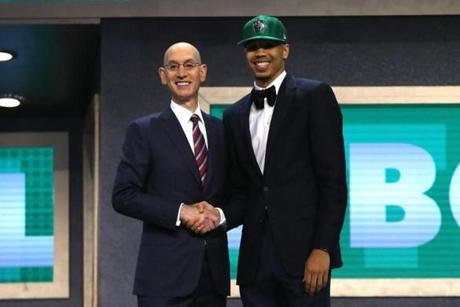 Jayson Tatum walked on stage with NBA commissioner Adam Silver after being drafted third overall by the Boston Celtics on Thursday. 

