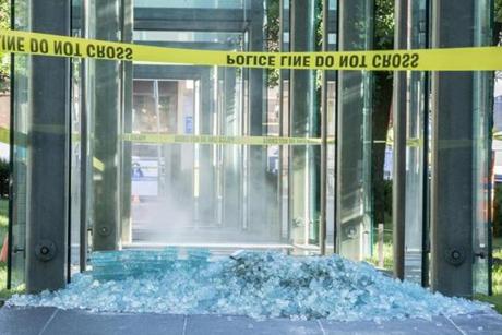 Shards of class covered the ground where a vandal damaged a pane of glass. 
