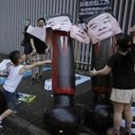 Children defaced images of former Hong Kong chief executive Leung Chun-ying as their families attended a pro-democracy protest in Hong Kong on Saturday.