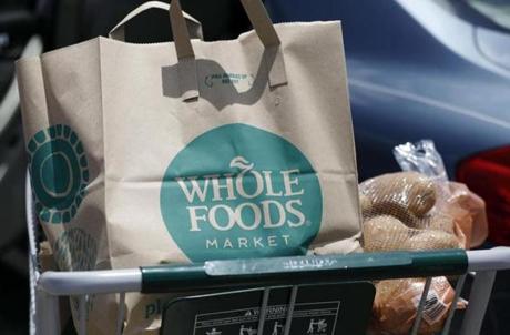 FILE - In this Friday, June 16, 2017, file photo, groceries from Whole Foods Market sit in a cart before being loaded into a car, outside a store in Jackson, Miss. Some small and mid-sized food companies are wondering how Amazon?s planned purchase of Whole Foods might affect them. The unknowns include whether Amazon might change the grocery chain?s food offerings, which now include thousands of products from small and mid-sized businesses. A key question for many companies is whether Whole Foods would place less of an emphasis on buying locally produced and innovative foods in the future. (AP Photo/Rogelio V. Solis, File)

