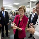Senator Elizabeth Warren and pharmacy operations manager Donato Mazzola spoke Monday about an automatic prescription-filling machine during a tour of the East Boston Neighborhood Health Center. Patients and staff at the center thanked Warren for her efforts to uphold the Affordable Care Act.