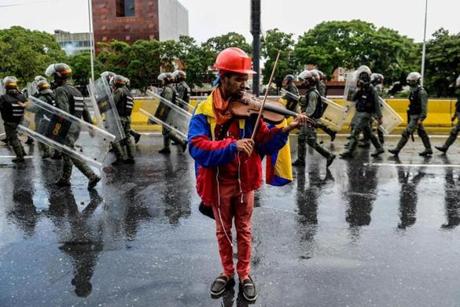 (FILES) This file photo taken on May 24, 2017 shows opposition activist and violin player Wuilly Arteaga during a protest against President Nicolas Maduro in Caracas. According to a human rights NGO report, Artega, 23, was arrested on July 27, 2017, during a protest within a 48-hour strike called by the opposition. / AFP PHOTO / FEDERICO PARRA
