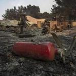 SANTA BARBARA, CA - JULY 09: A burned fire extinguisher is seen next to structures at Rancho Alegre Boy Scouts of America outdoor school that were destroyed by the Whittier Fire on July 9, 2017 near Santa Barbara, California. The Whittier Fire and the Alamo Fire together have blackened more than 30,000 acres of chaparral-covered hills in Ventura County. Statewide, about 5,000 firefighters are fighting 14 large wildfires. (Photo by David McNew/Getty Images)