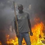 A supporter of opposition leader Raila Odinga stands in front of a burning barricade Saturday in Nairobi.