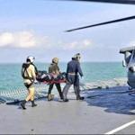A body recovered by the Royal Malaysian Navy is taken Wednesday to a US Navy helicopter off the Malaysian coast.