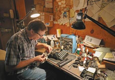Tom Furrier, the last typewriter repairman in the area, works on a vintage Corona in his Arlington shop. Many of his old machines, such as the Royals and Remington Rand below, are used for parts.
