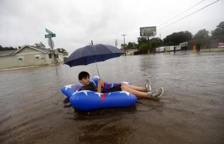 HARVEY SLIDER6 Julius Verret, 14, floats in street flooding in Lake Charles, La., as the city is receiving heavy rains from Tropical Storm Harvey, Sunday, Aug. 27, 2017. The storm came ashore on the Texas Gulf Coast as a category four hurricane. (AP Photo/Gerald Herbert)
