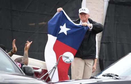 SLIDER - US President holds the state flag of Texas outside of the Annaville Fire House after attending a briefing on Hurricane Harvey in Corpus Christi, Texas on August 29, 2017. President Donald Trump flew into storm-ravaged Texas Tuesday in a show of solidarity and leadership in the face of the deadly devastation wrought by Harvey -- as the battered US Gulf Coast braces for even more torrential rain. / AFP PHOTO / JIM WATSONJIM WATSON/AFP/Getty Images
