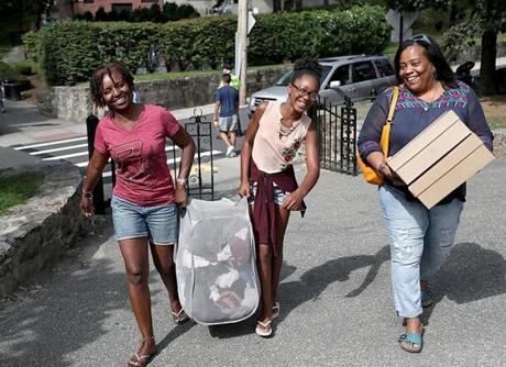 It took a family to move a student into Boston College. In this case, Isaiah Mathieu, not pictured, got help from, from left to right, his mother, Judith, sister, Brianah, and aunt Elizebeth Olivier.
