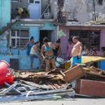 People clear debris outside their homes after the passing of Hurricane Irma in Havana, Cuba, Monday, Sept. 11, 2017. Cuban state media reported 10 deaths despite the country's usually rigorous disaster preparations. More than 1 million were evacuated from flood-prone areas. (AP Photo/Desmond Boylan)