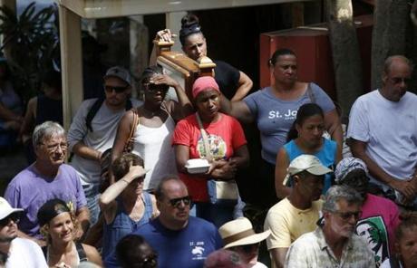 STJOHN SLIDER Cruz Bay, St. John -- 9/13/2017 - People listen to information about evacuations and updates about the current situation on the island during a community meeting held at Mongoose Junction in Cruz Bay, St. John. (Jessica Rinaldi/Globe Staff) Topic: Reporter: 
