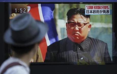 A man watched a TV news program on a public screen showing an image of North Korean leader Kim Jong Un.
