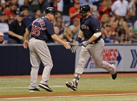 Boston Red Sox third base coach Brian Butterfield, left, congratulates Mitch Moreland on his solo home run off Tampa Bay Rays starter Matt Andriese during the fourth inning of a baseball game Friday, Sept. 15, 2017, in St. Petersburg, Fla. (AP Photo/Steve Nesius)

